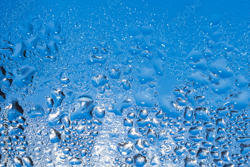 Abstract blue background. Liquid on dirty glass.Frozen water drops on glass,closeup,selective soft focus.Copy space.