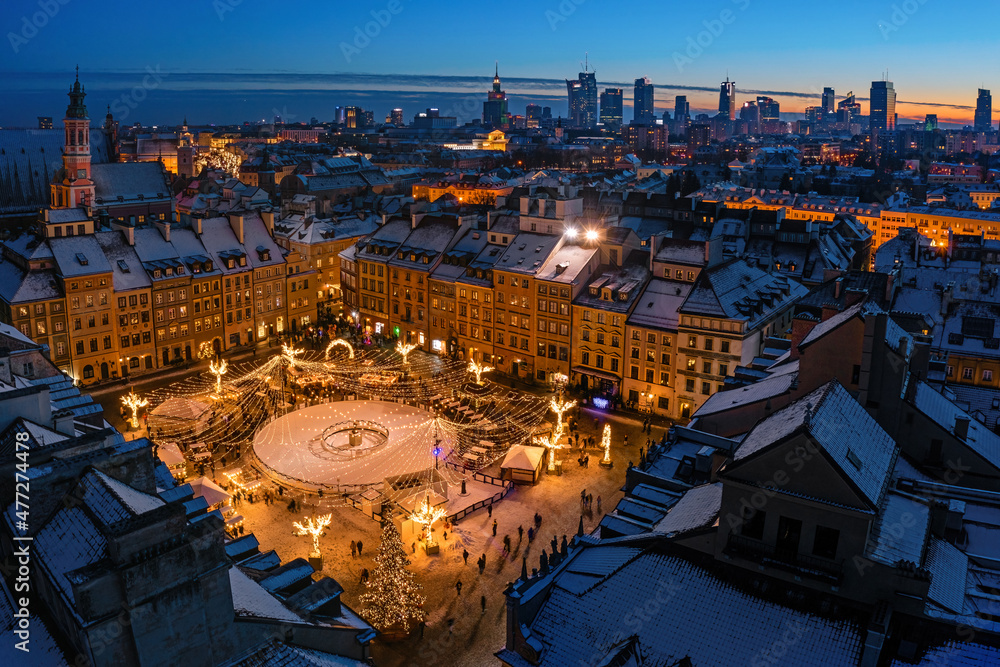 Warszawa, rynek starego miasta udekorowany świątecznym oświetleniem, widok z lotu ptaka na ośnieżone budynki i centrum miasta w oddali - obrazy, fototapety, plakaty 