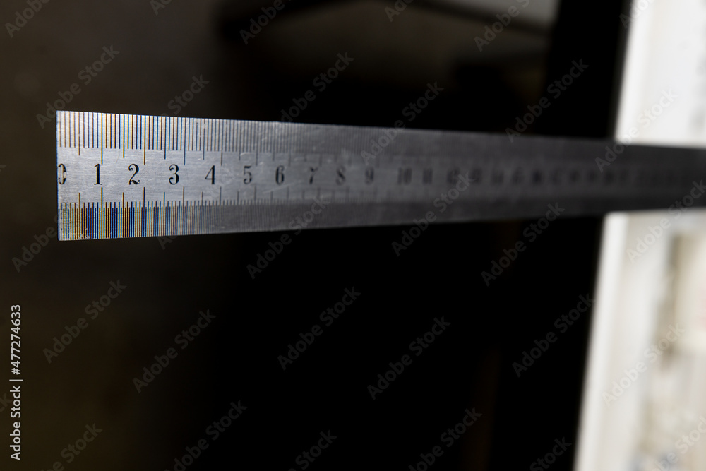 iron ruler with numbers on black background iron ruler with numbers on black background