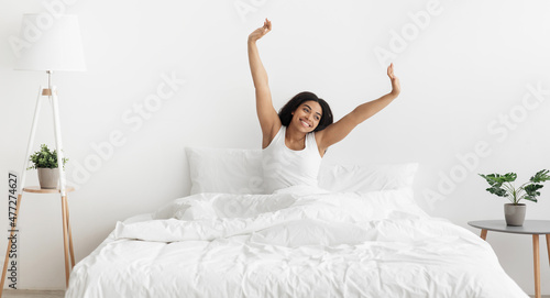 Wallpaper Mural Good morning, great mood and vitality. Happy african american woman sitting on comfortable bed and stretching, panorama Torontodigital.ca