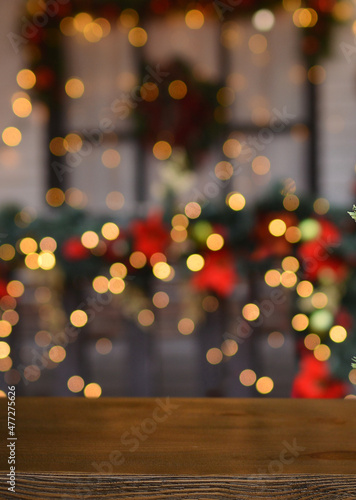 Christmas background. Empty wooden board on background of blurred christmas house outdoors and New Year's golden bokeh.Ready for product montage. Banner. Copy space