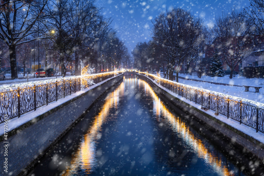 Fototapeta premium Christmas lights over the Radunia canal in Pruszcz Gdanski at dusk, Poland.