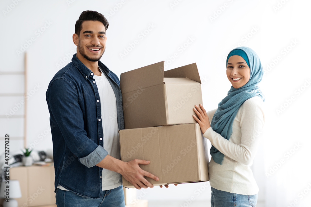 Pretty woman in hijab giving her husband paper boxes Pretty woman in hijab giving her husband paper boxes