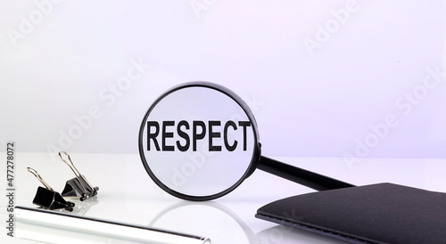 RESPECT text concept. Magnifier glass with text with notebook and pen,business