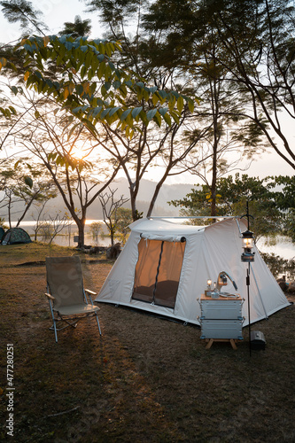 Camping tent on campsite with panoramic view in evening sunset. cozy tents for recreation near lake. people outdoors activity camping.