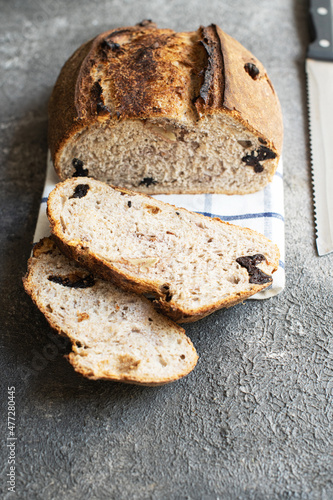 Freshly baked sourdough bread with dried apricots and prunes on a gray background.
