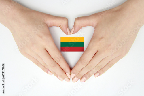 Women's hands create a heart inside the Lithuanian flag on a white background.Background for postcards and banners for Independence Day, Flag Day, travel, patriotism, love for the country. photo