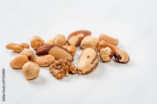 Different nuts are scattered on a white background. Walnuts, hazelnuts and Brazil nuts. The concept of healthy eating and snacking