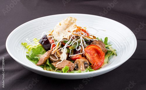 Salad with beef and fresh vegetables with mushrooms.