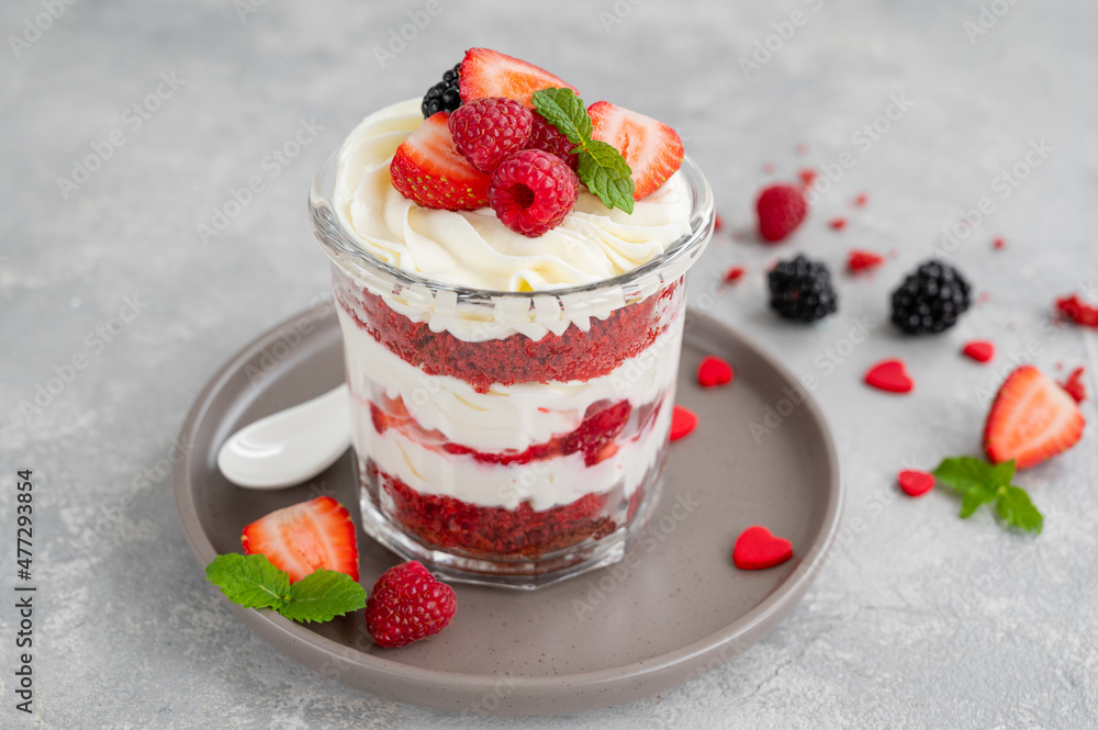 Red Velvet cake trifle with fresh berries in a glass jar on a gray concrete background. Dessert for Valentine's Day. Copy space. Red Velvet cake trifle with fresh berries in a glass jar on a gray concrete background. Dessert for Valentine's Day. Copy space.