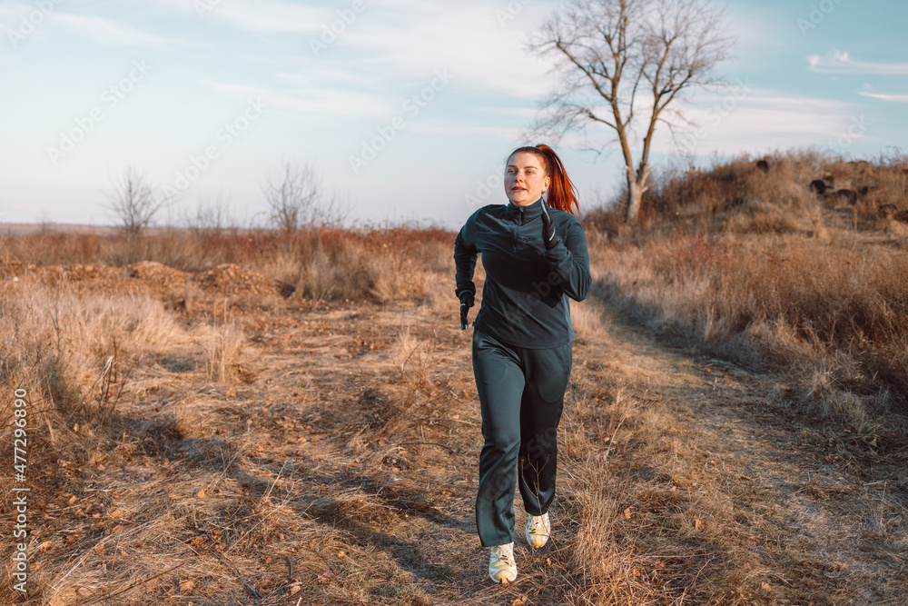 Runner caucasian woman jogging in autumn park. Healthy lifestyle concept. Active sports people