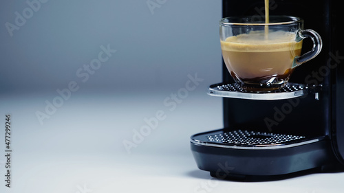 Fotografie, Obraz automatic coffee maker pouring hot drink into cup on gray.