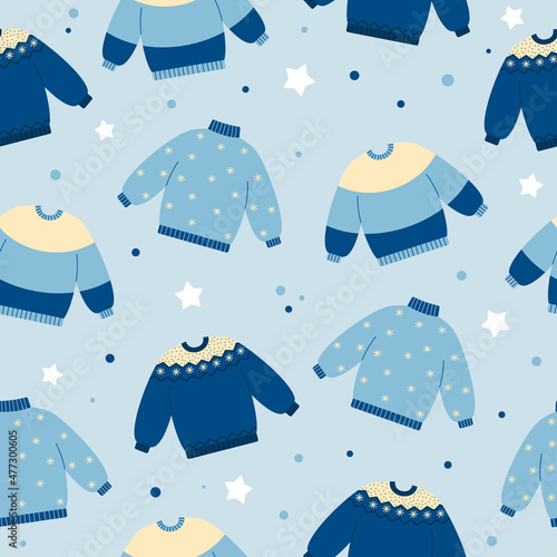 Seamless pattern of warm sweaters in blue colors on blue background. Winter or autumn clothing background. Doodle style. Christmas holidays mood.
