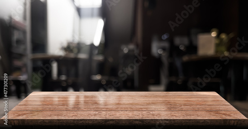 Empty wooden table top with lights bokeh on blur restaurant background.