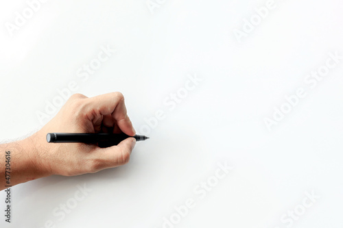 man's hand holding a pen writing on white background. space for text