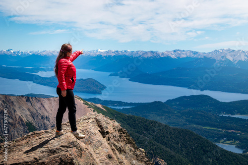 Mujer senderista señalado montañas en la lejania, el el cerro catedral de Bariloche. Patagonia Argentina © Javier