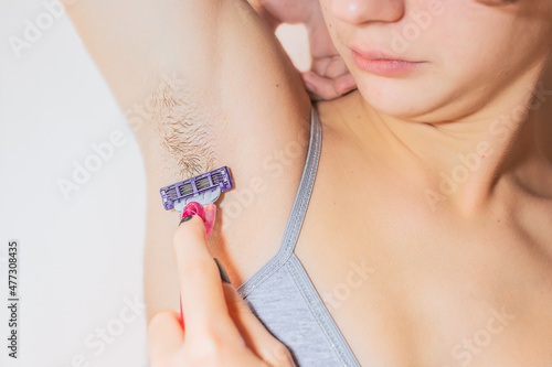 Young teen girl shaves her armpit hair for the first time photo