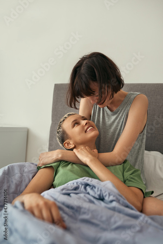 Young lesbians resting on bed together at morning