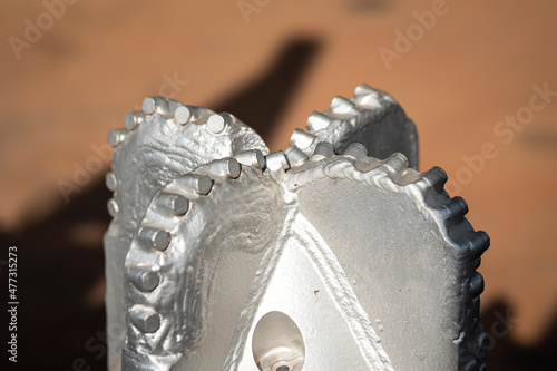 A polycrystalline carbide drill bit, using for drill a subsurface rock structure in oil drilling operation. Oil industrial heavy equipment object photo. Close-up and selective focus. photo