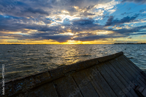 Sunset panorama over the Chascomus lagoon  Argentina  with fallen wall
