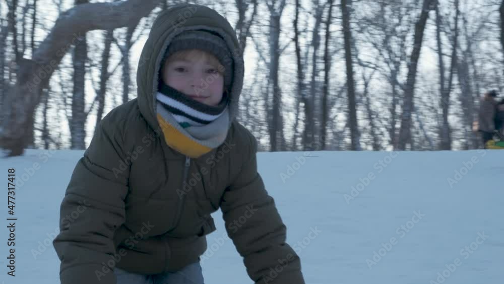 Smiling children playing with snow outdoors. Boy having fun in winter park with friends in vacation and holidays. Emotion, happiness, lifestyle concept. Snowboarder on the slope Smiling children playing with snow outdoors. Boy having fun in winter park with friends in vacation and holidays. Emotion, happiness, lifestyle concept. Snowboarder on the slope