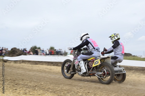 motocross bikers on motorcycles with carrycot