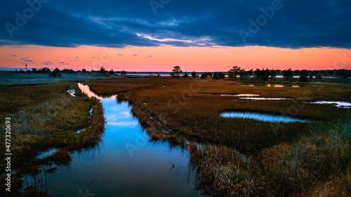 Fototapeta Naklejka Na Ścianę i Meble -  Dramatic twilight seascape over the marshland river at South Cape Beach in Mashpee, Massachusetts.