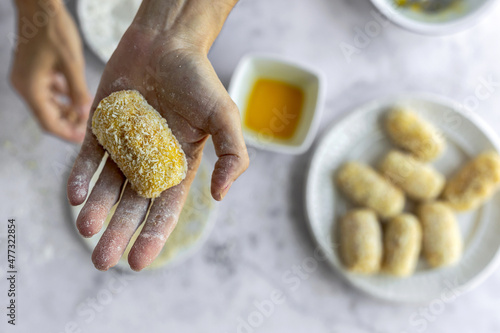 Faceless chef showing breaded croquette