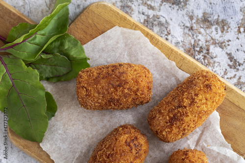 Delicious croquettes with ham on cutting board photo