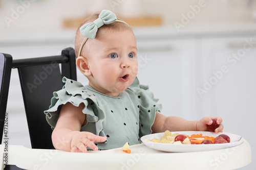 Cute little girl eating healthy food at home
