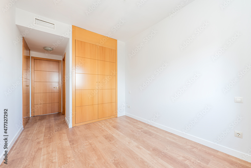 empty room with built-in wardrobe in cherry color and parquet floors empty room with built-in wardrobe in cherry color and parquet floors