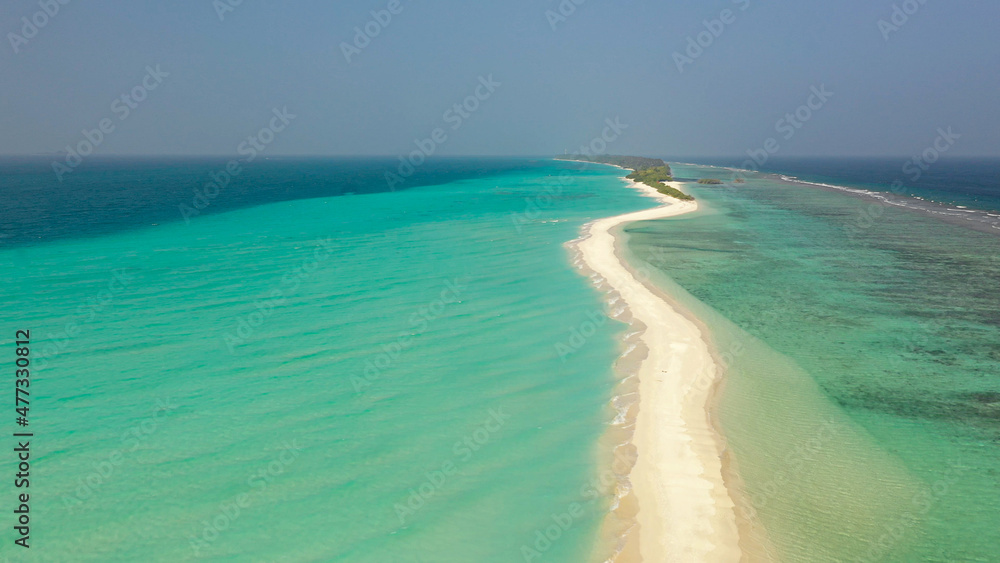 Aerial view of a tropical island with a sandbank, surrounded by turquoise water. Dhigurah island, Maldives. Aerial view of a tropical island with a sandbank, surrounded by turquoise water. Dhigurah island, Maldives.