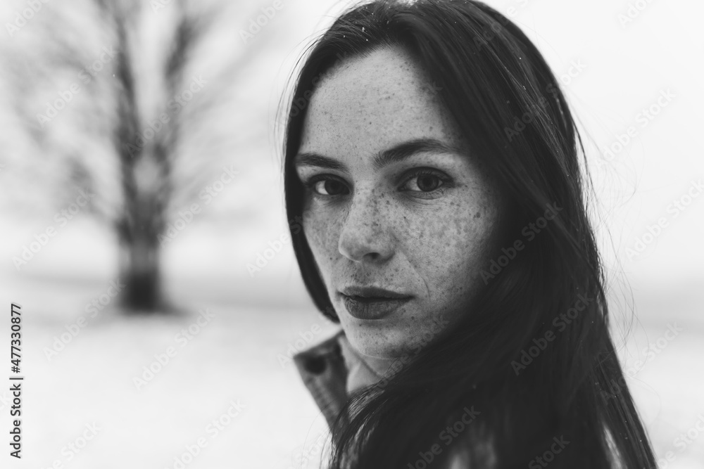 Close up red haired freckled woman monochrome portrait outdoor in winter snowy park Close up red haired freckled woman monochrome portrait outdoor in winter snowy park