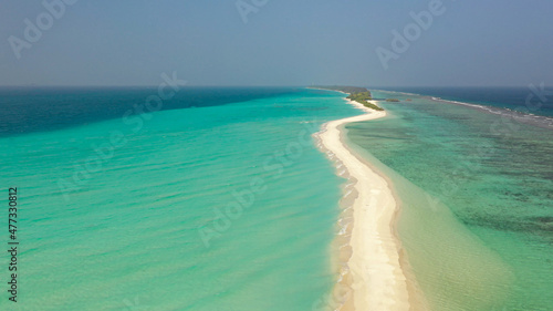 Aerial view of a tropical island with a sandbank, surrounded by turquoise water. Dhigurah island, Maldives. photo