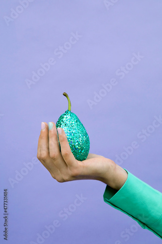 Girl holding glittered pear by lavender background photo