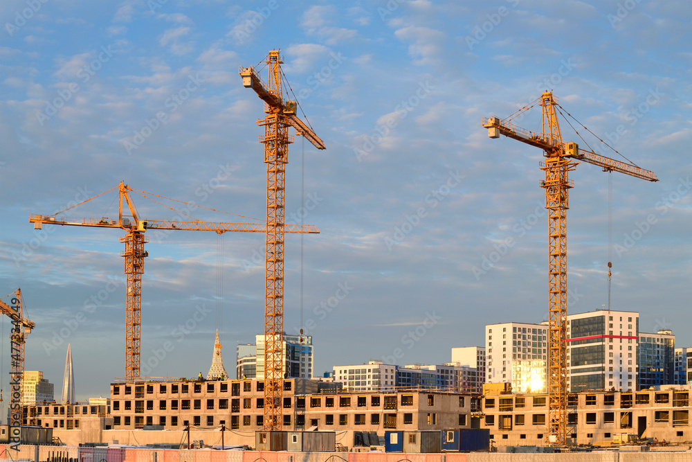 Construction cranes on the construction site of a apartment building on a December afternoon. Saint-Petersburg, Russia Construction cranes on the construction site of a apartment building on a December afternoon. Saint-Petersburg, Russia
