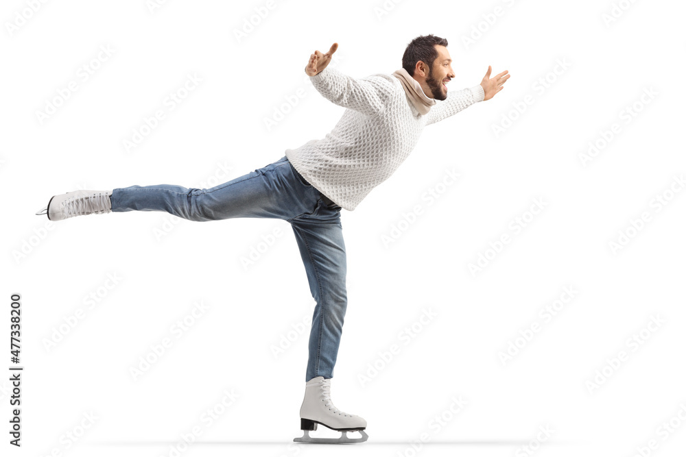 Full length profile shot of a man in jeans and white knitwear performing ice skating Full length profile shot of a man in jeans and white knitwear performing ice skating