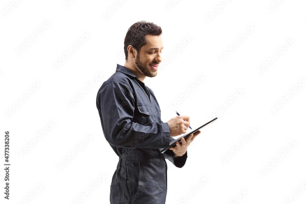 Male worker in a uniform writing on a document with a clipboard Male worker in a uniform writing on a document with a clipboard