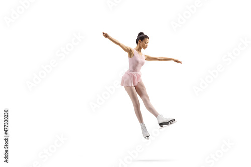 Fototapeta Naklejka Na Ścianę i Meble -  Full length shot of a professional female figure skater in a pink dress performing a jump
