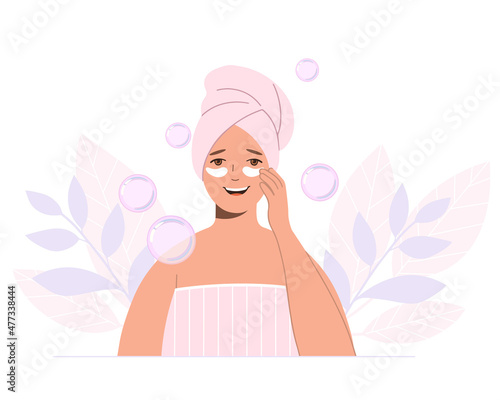Beautiful woman with a towel on her head takes care of skin of her face. Spa procedure.