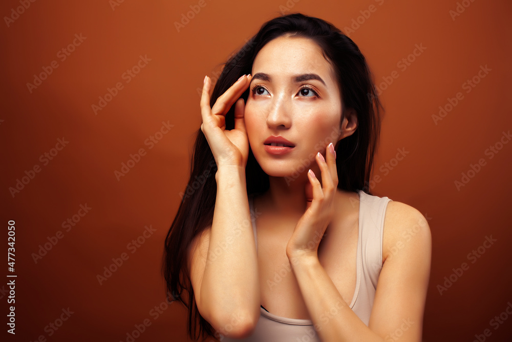 young pretty asian woman cheerful smiling posing on warm brown background, lifestyle people concept young pretty asian woman cheerful smiling posing on warm brown background, lifestyle people concept