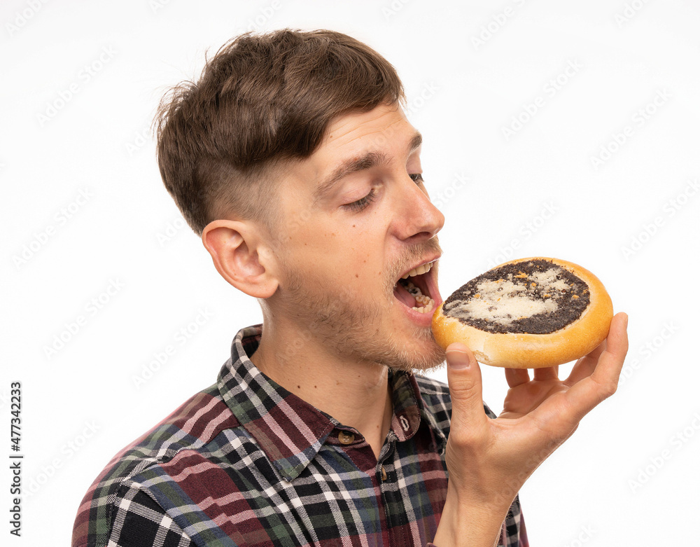 Young handsome tall slim white man with brown hair biting into kolach eyes closed in flannel shirt isolated on white background Young handsome tall slim white man with brown hair biting into kolach eyes closed in flannel shirt isolated on white background