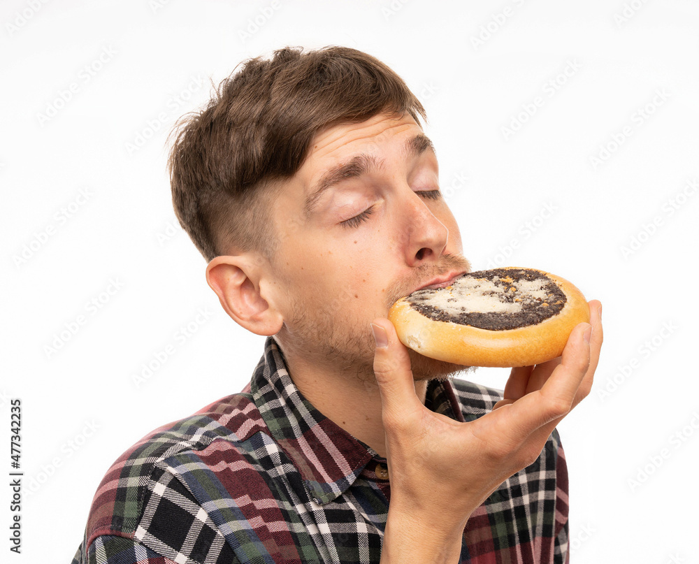 Young handsome tall slim white man with brown hair biitng into kolach looking dreamy in flannel shirt isolated on white background Young handsome tall slim white man with brown hair biitng into kolach looking dreamy in flannel shirt isolated on white background