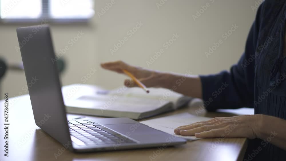 Closeup of teachers hands as she shows work to remote student on computer in video chat. Closeup of teachers hands as she shows work to remote student on computer in video chat.