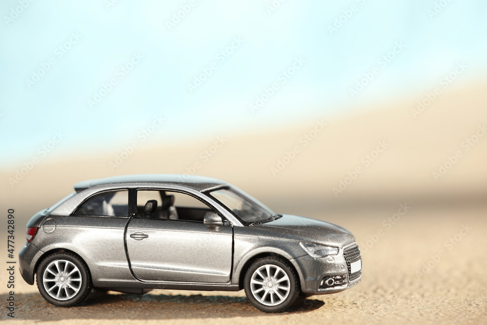 Miniature car model outdoors on sunny day. Space for text