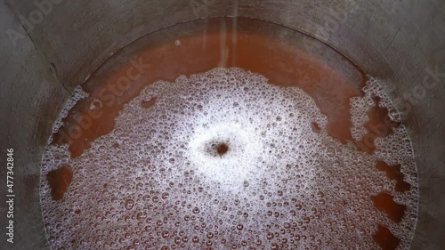 Close up stream of apple juice splashing into stainless steel round container. Red juice from organic apples dripping from juicing machine. Extractor apple juice in the kitchen 4K