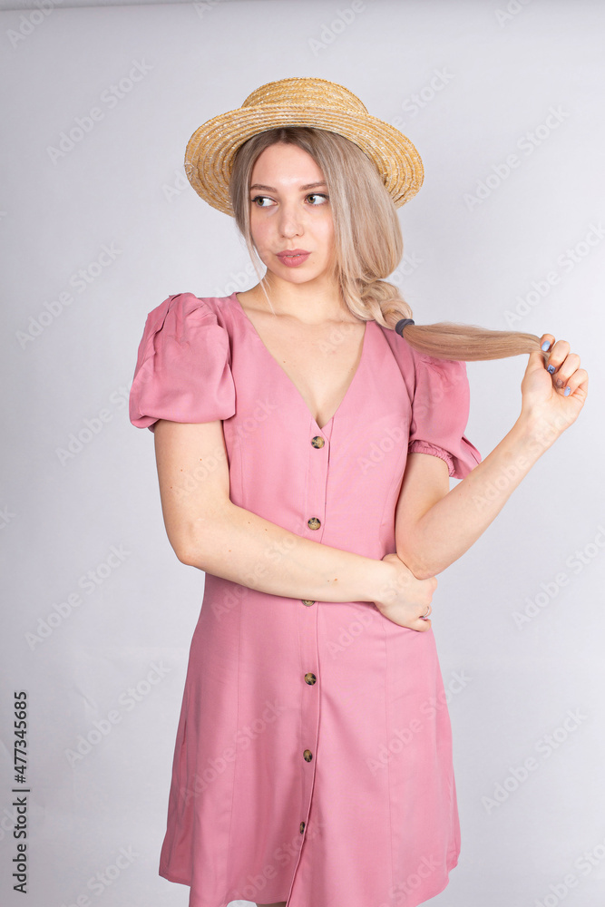 Woman with blonde hair and white skin isolated on grey in pink dress Woman with blonde hair and white skin isolated on grey in pink dress