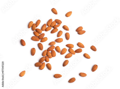 Scattered brown almonds isolated on white background. Close-up view of raw organic nuts. Healthy food for life concept. Vegan and vegetarian tasty snack full of vitamins and oils 