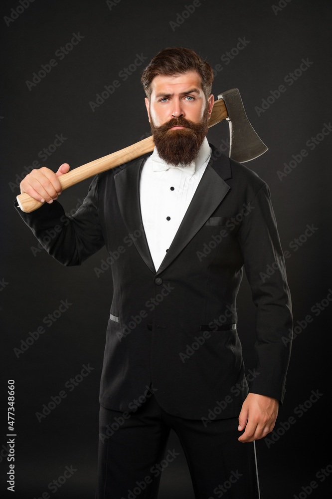 Serious unshaven man with beard and moustache in formal suit holding axe dark background, brutal Serious unshaven man with beard and moustache in formal suit holding axe dark background, brutal
