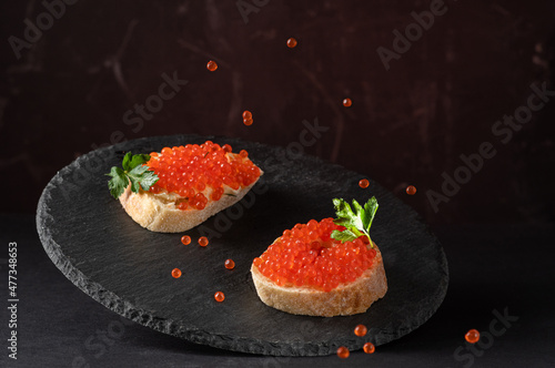 Sandwiches with red caviar. Sandwiches on a tray. Caviar flying over sandwiches. Food levitation.